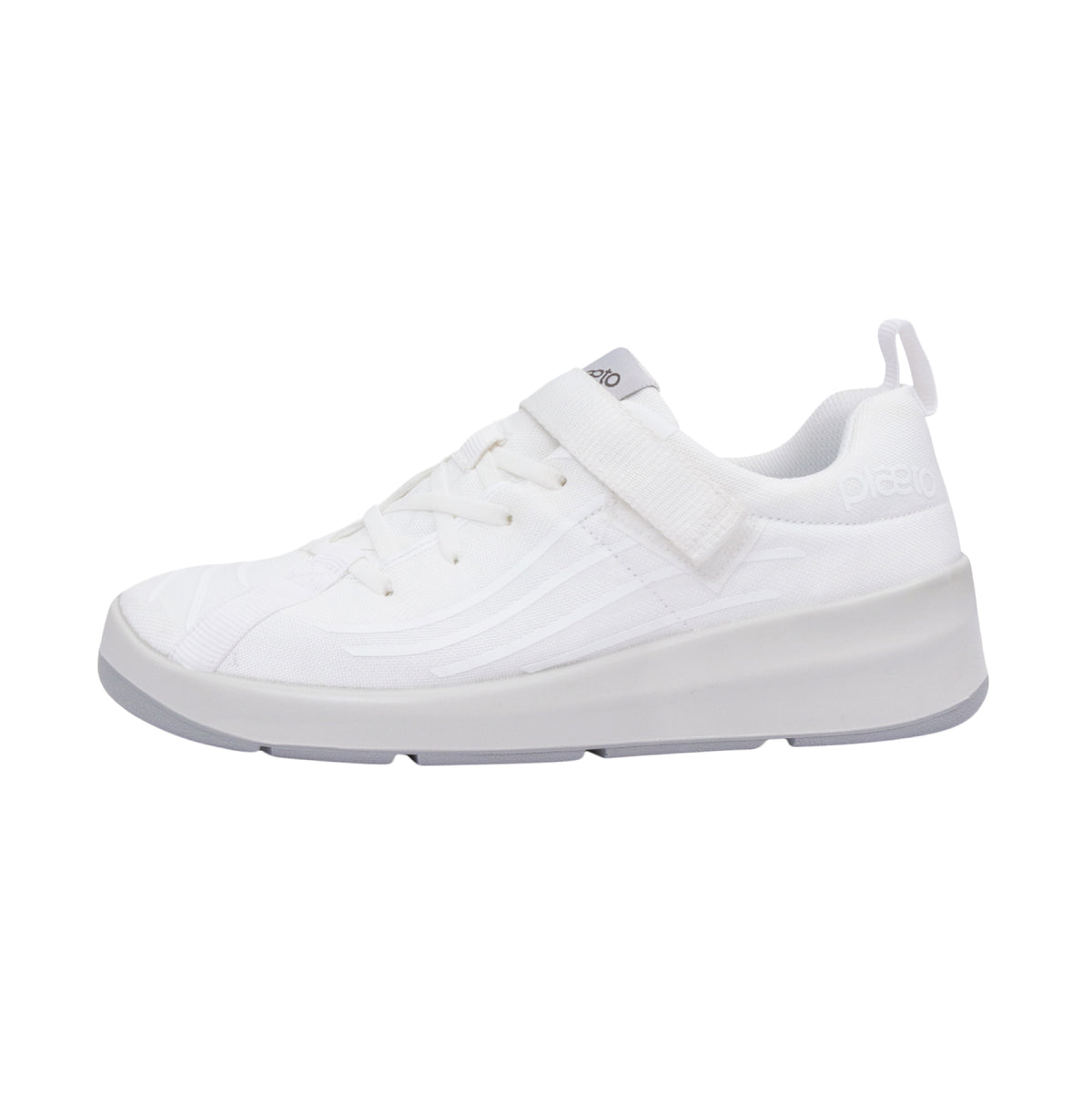 A white school shoe with Velcro straps and a flat sole.