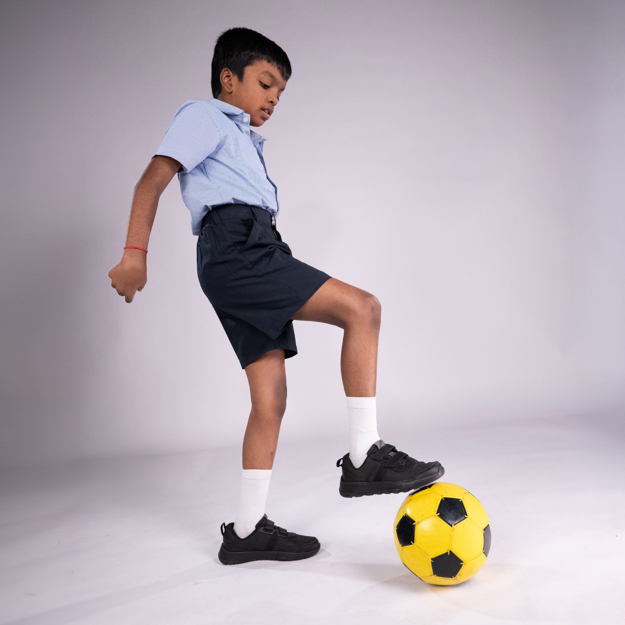 Child playing with a soccer ball on a plain background