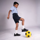 Child playing with a soccer ball on a plain background